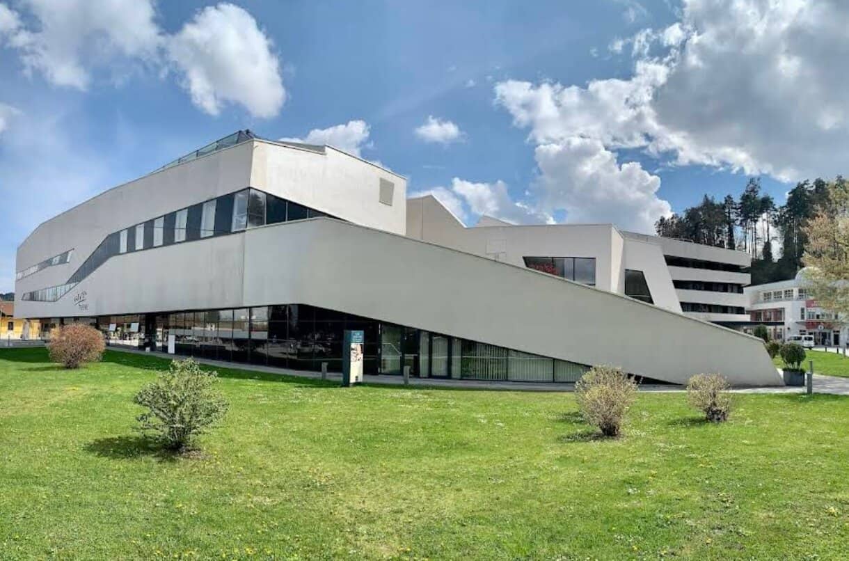 Außenansicht der futuristischen KärntenTherme mit geschwungener weißer Fassade